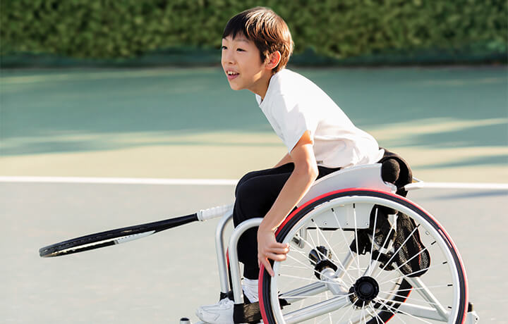 Boy playing tennis in wheelchair